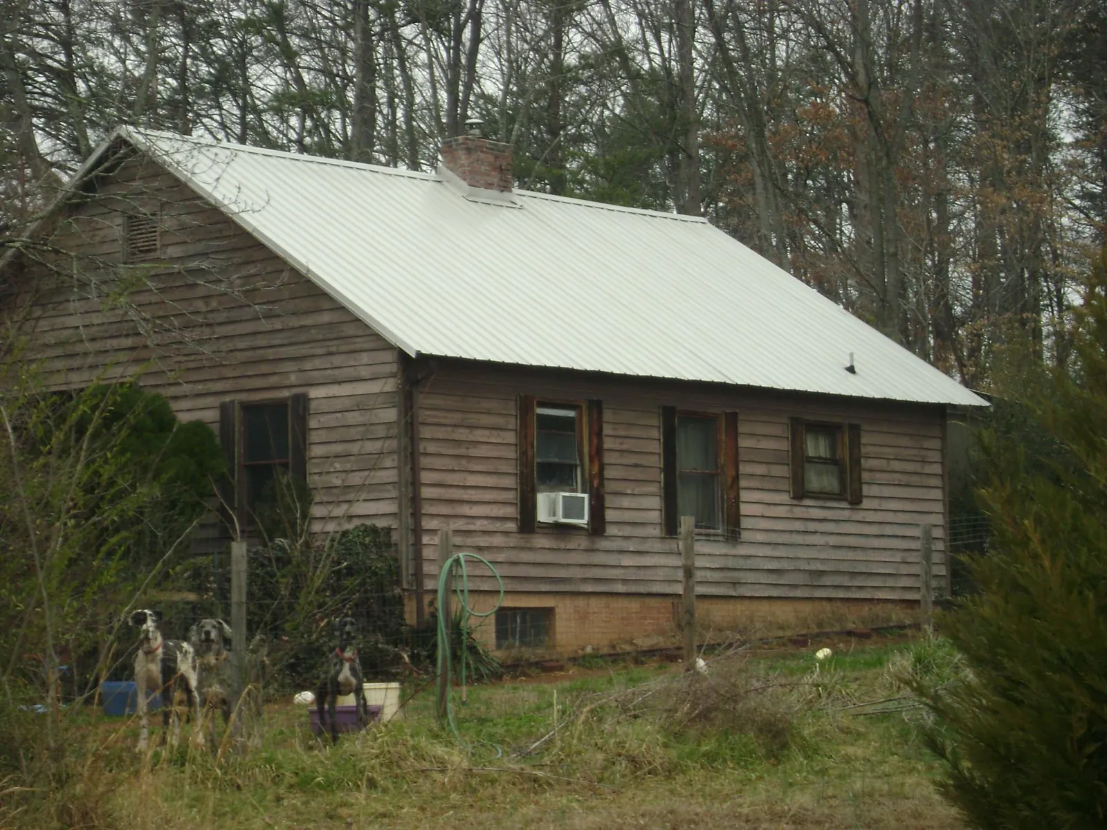 White metal roof on an old wood sided farmhouse, from a Metal Roof Installation job in Williamston